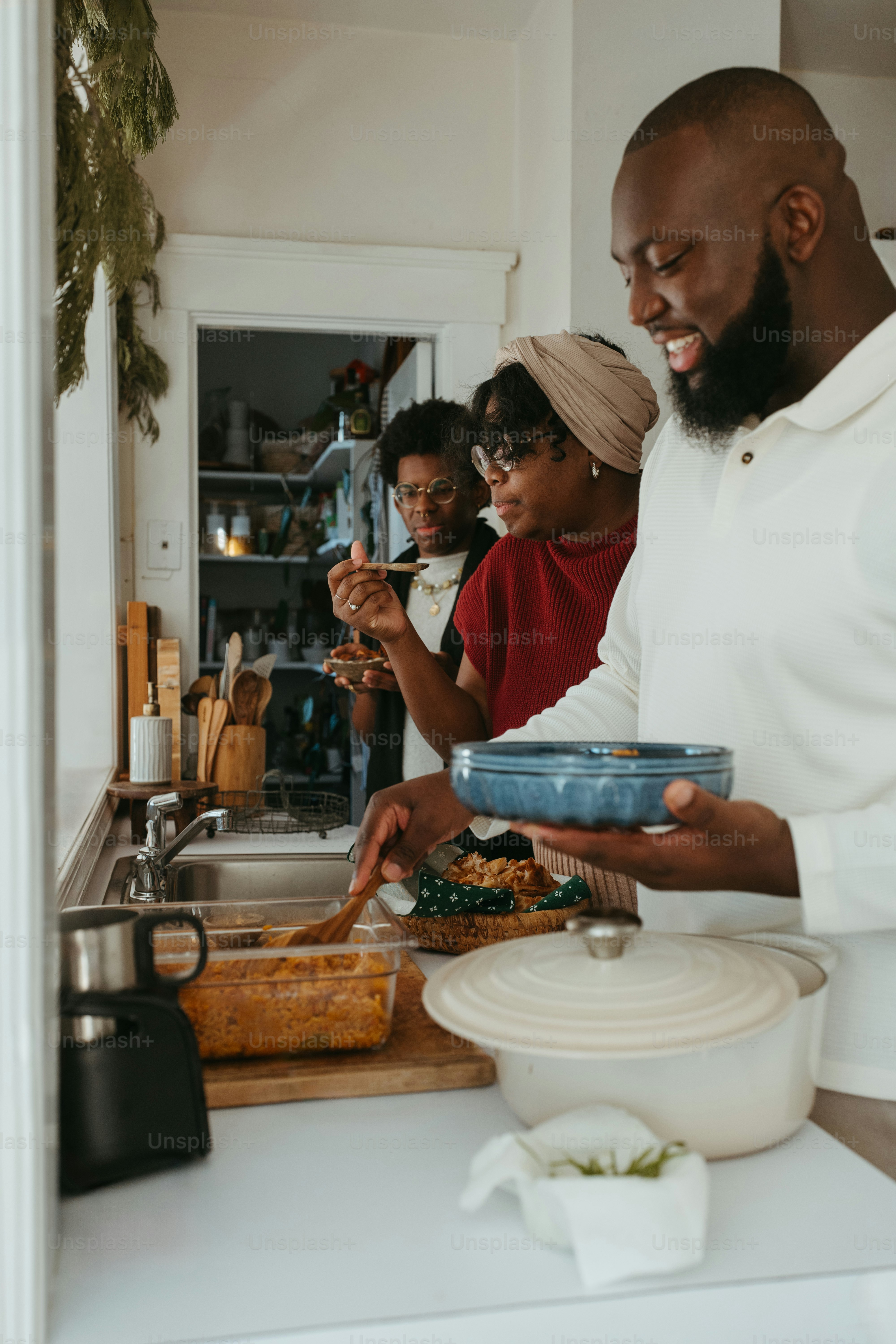 a group of people standing around a kitchen preparing food