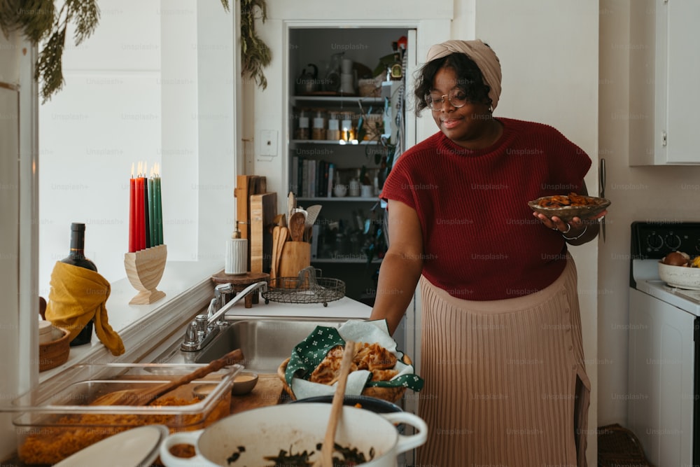 una donna in piedi in una cucina con in mano una ciotola di cibo