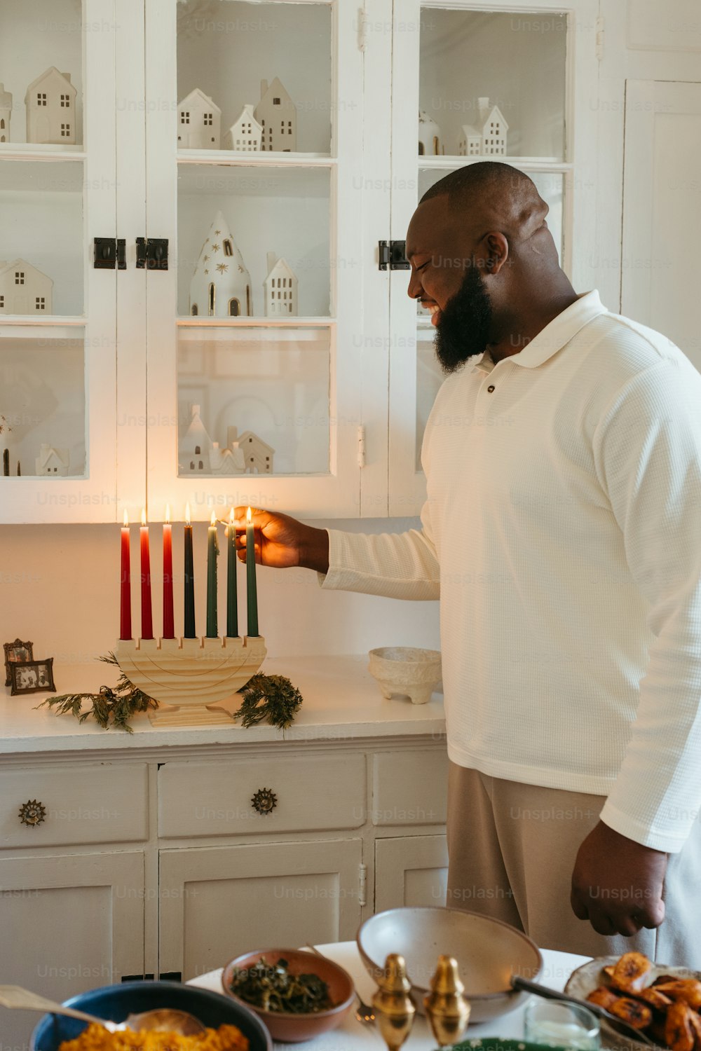 a man lighting a candle in a kitchen