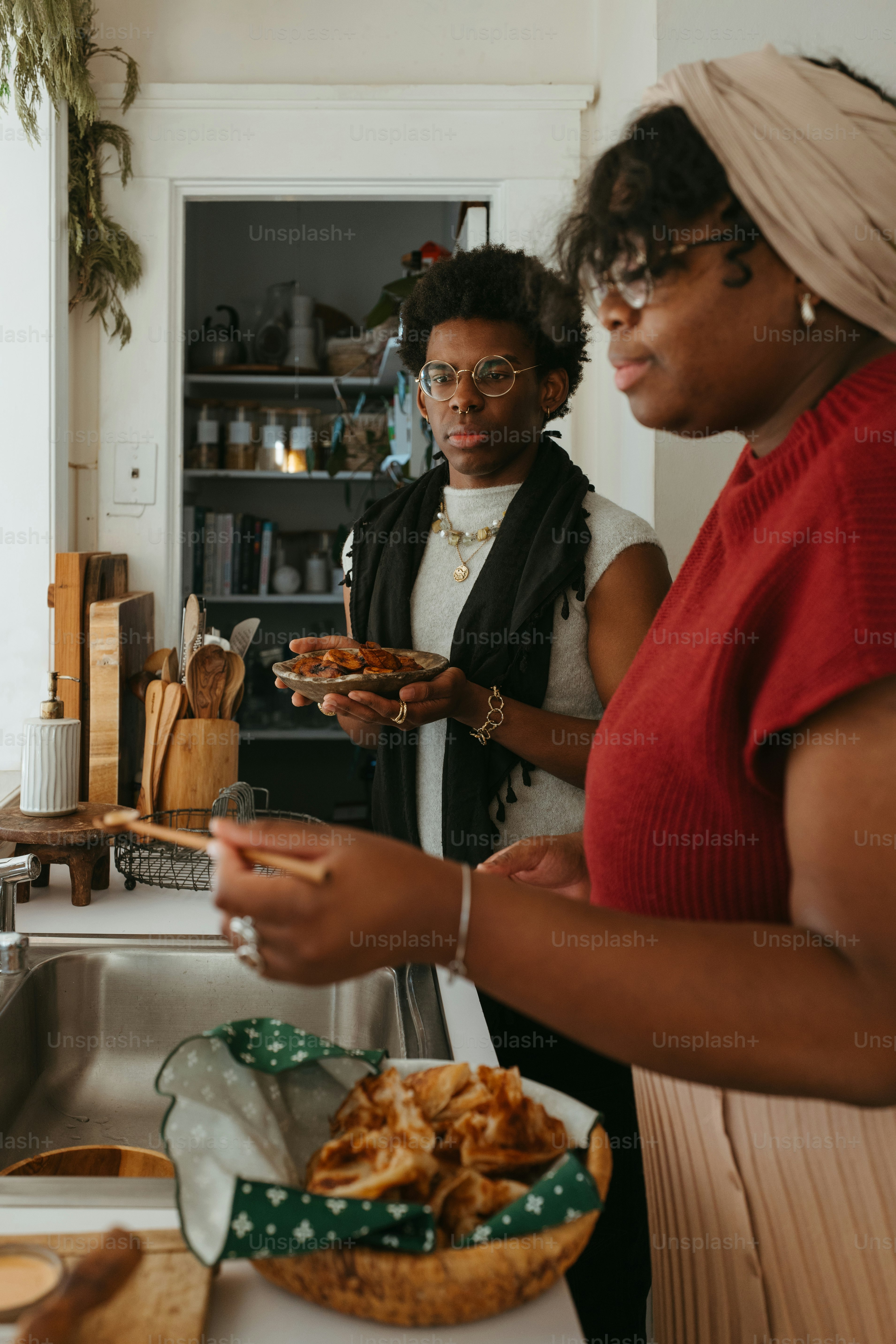 two women standing in a kitchen preparing food