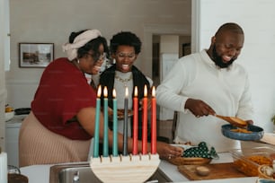 a group of people standing around a table with a cake