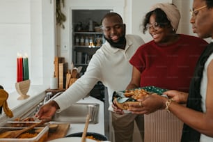 a group of people standing around a kitchen preparing food