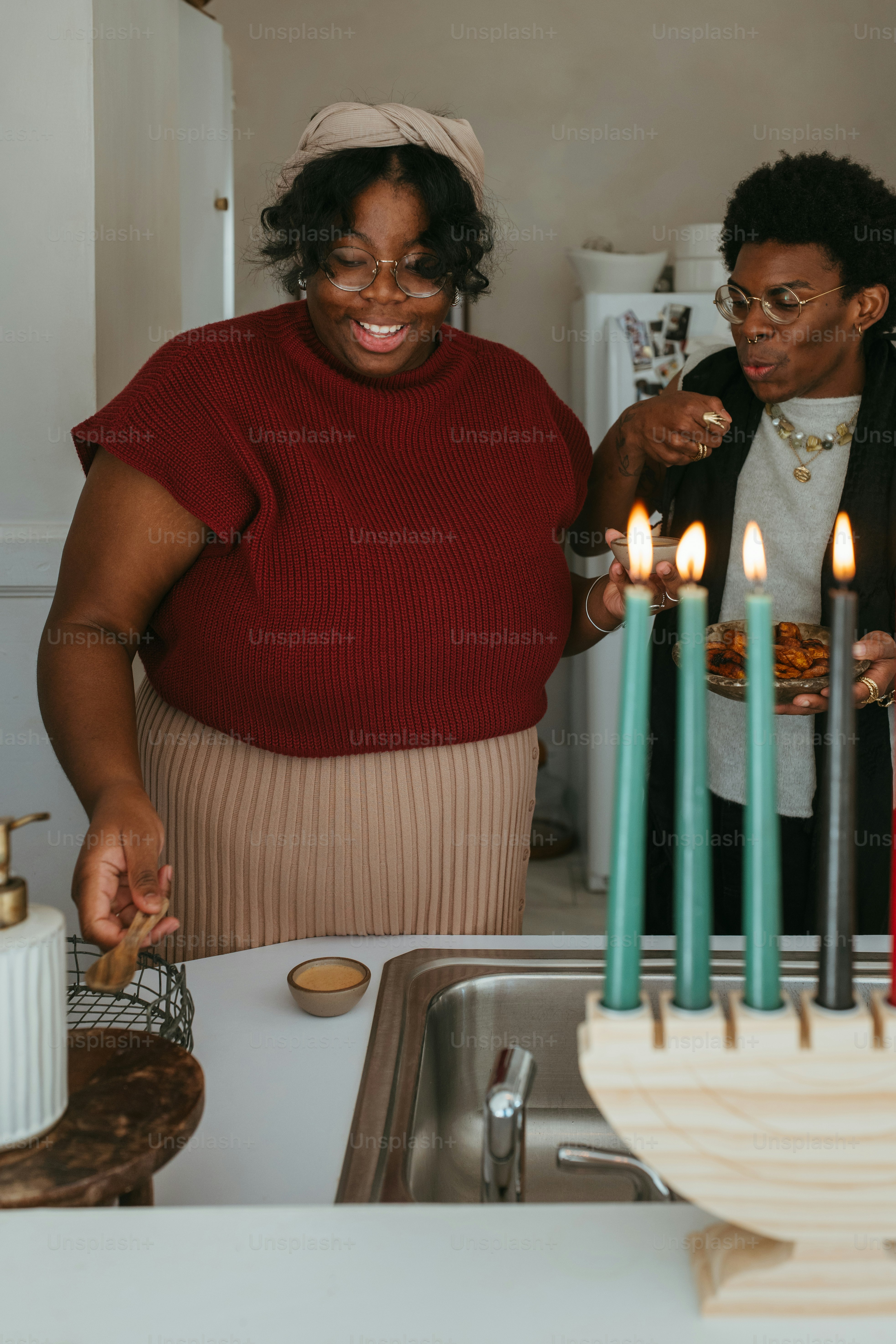 a woman standing in front of a cake with lit candles