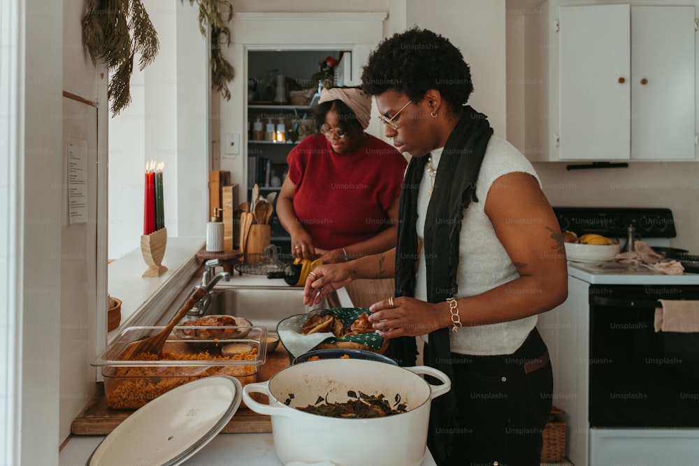 a couple of women standing in a kitchen preparing food