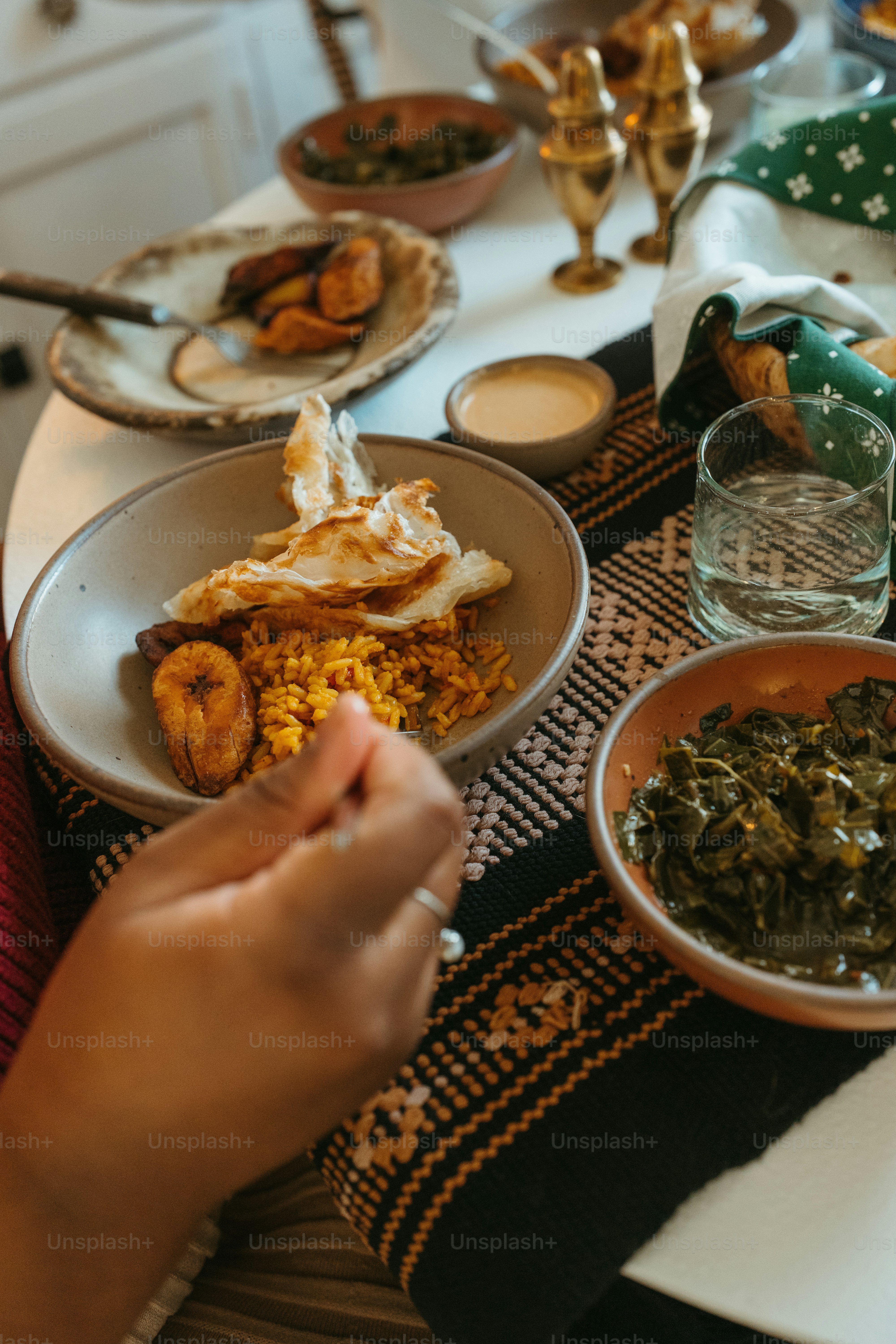 uma pessoa sentada em uma mesa com pratos de comida