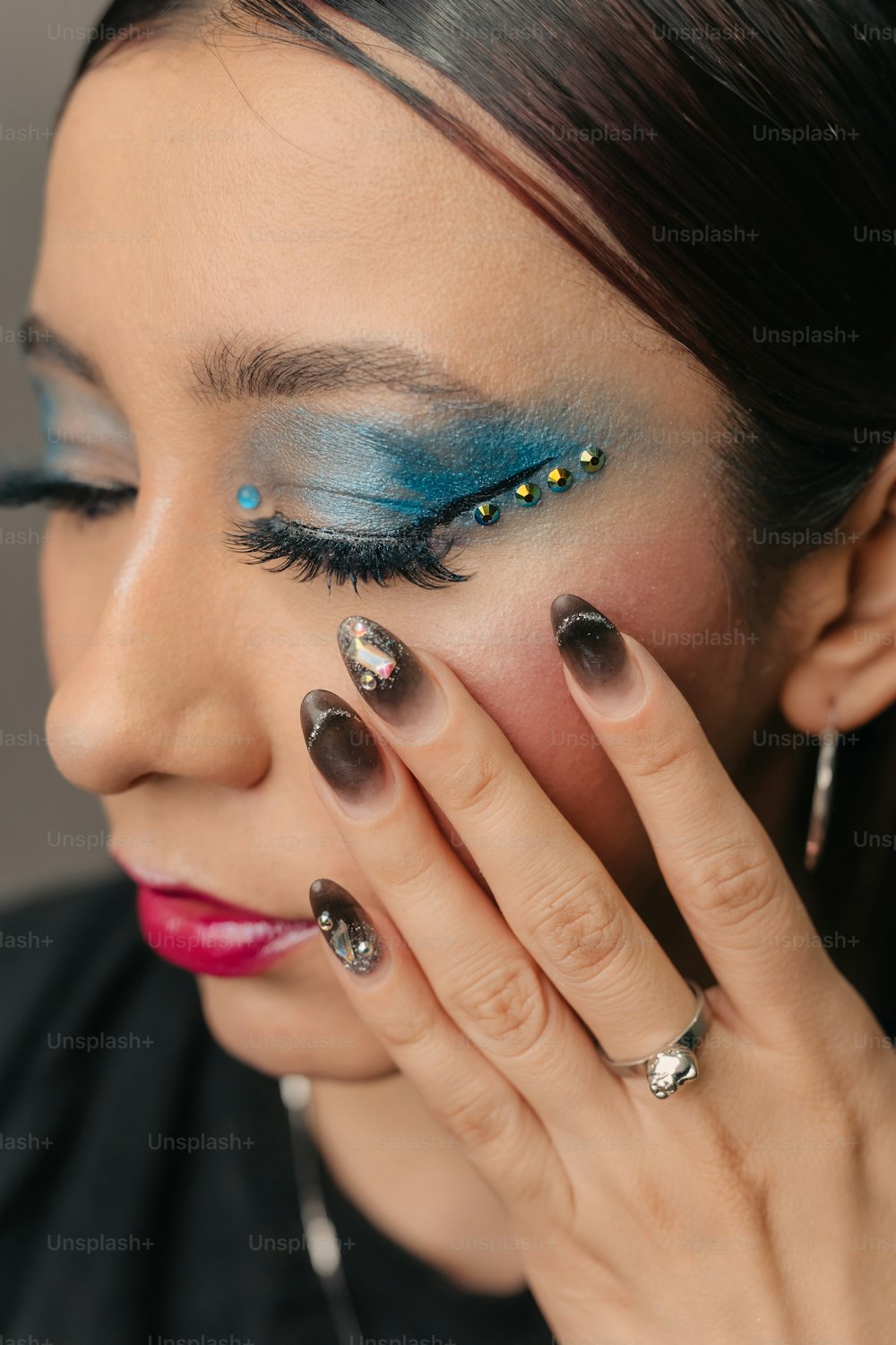 a close up of a woman with blue and silver makeup