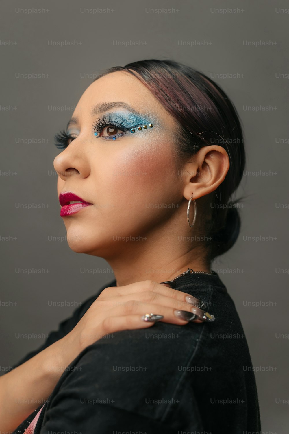 a woman with blue makeup and a black jacket