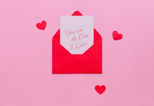Une enveloppe rouge avec une carte qui dit que tu es celle que j’aime