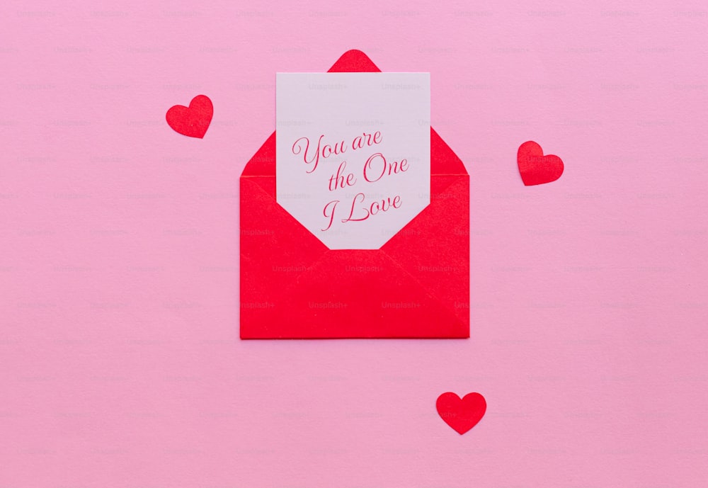 Une enveloppe rouge avec une carte qui dit que tu es celle que j’aime