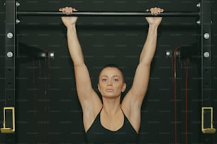 a woman doing a pull up on a bar