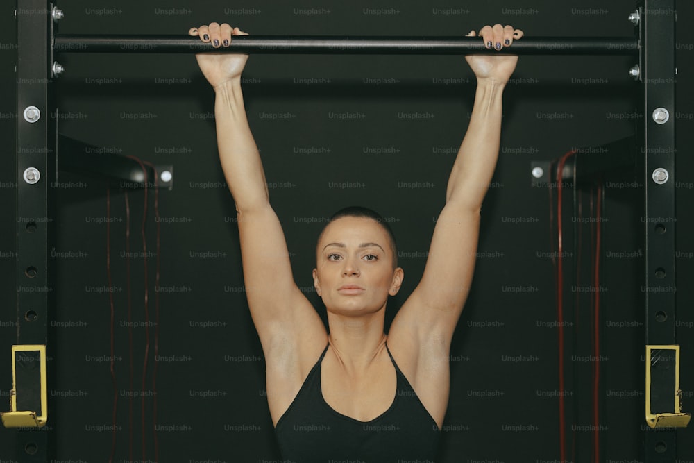 a woman doing a pull up on a bar