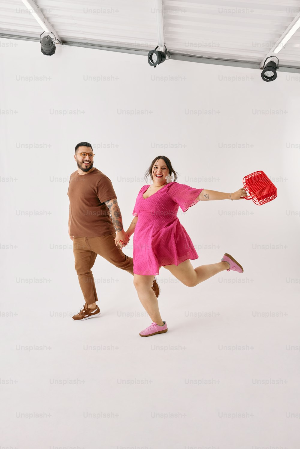 a man and a woman holding a red frisbee