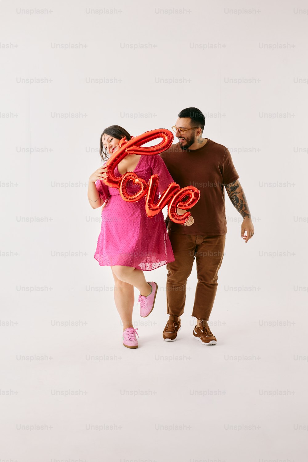 a man and a woman holding a giant love balloon