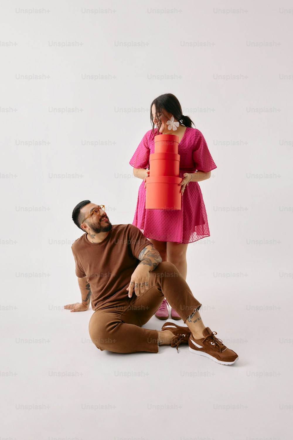 a man sitting on the ground next to a woman