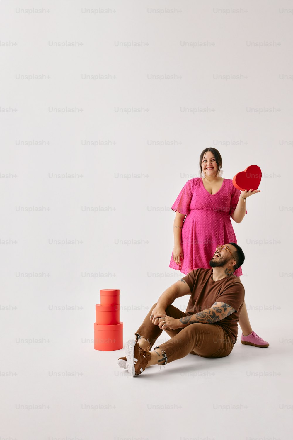 un homme tenant un frisbee rouge à côté d’une femme