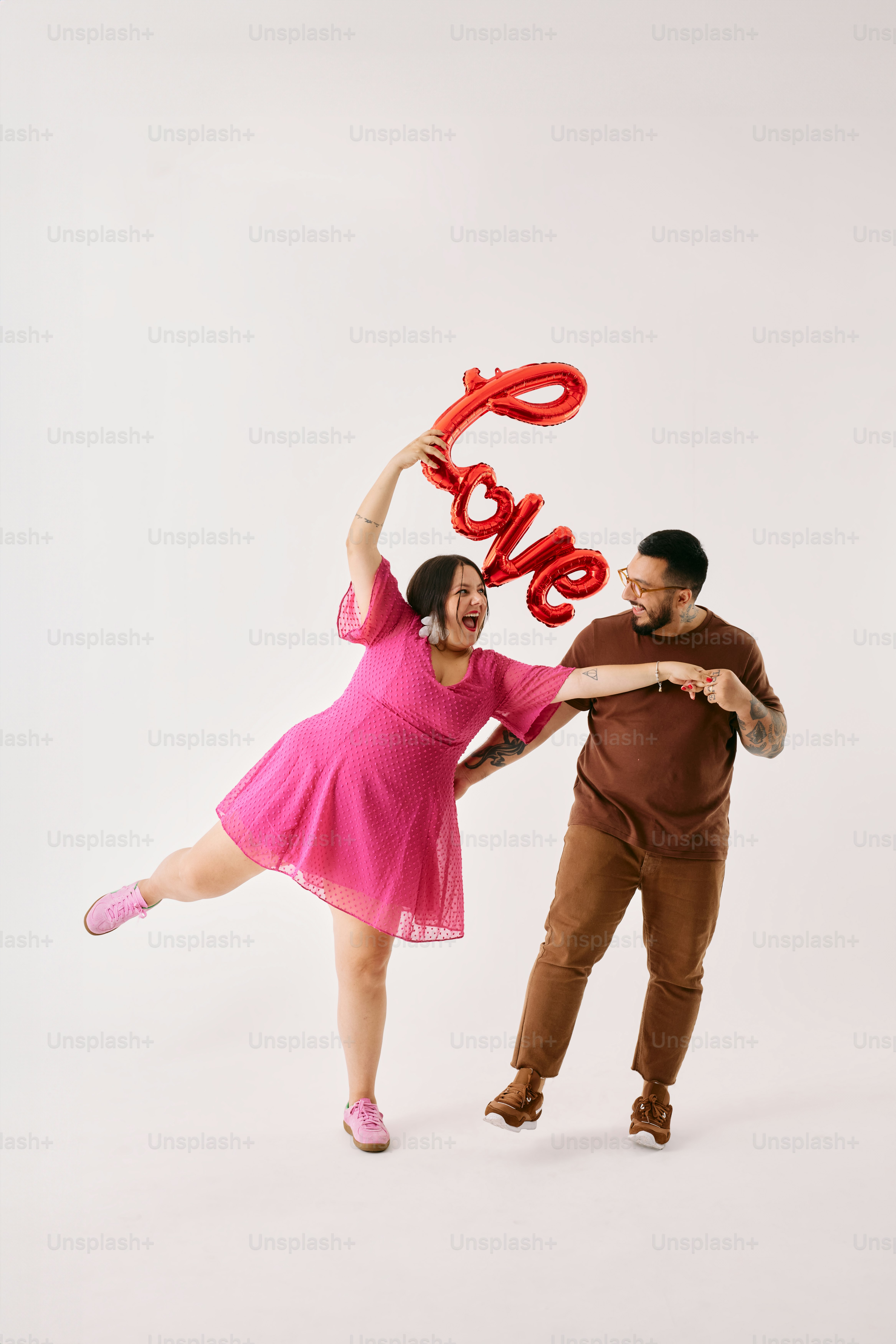 a man and a woman holding up a red balloon