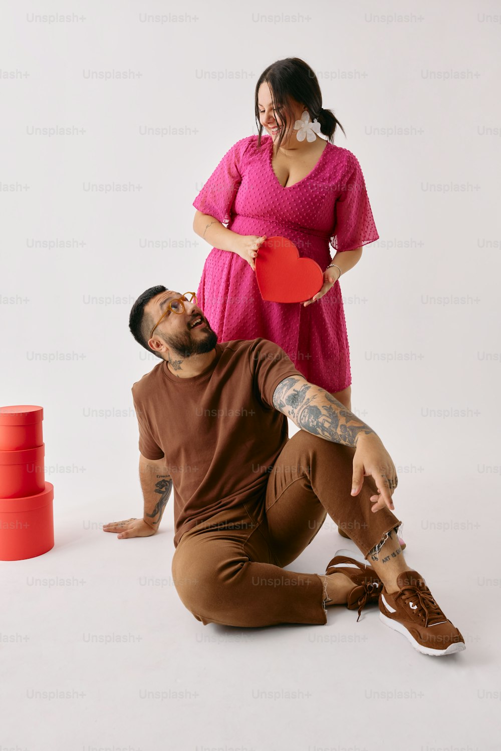 a man holding a red frisbee next to a woman