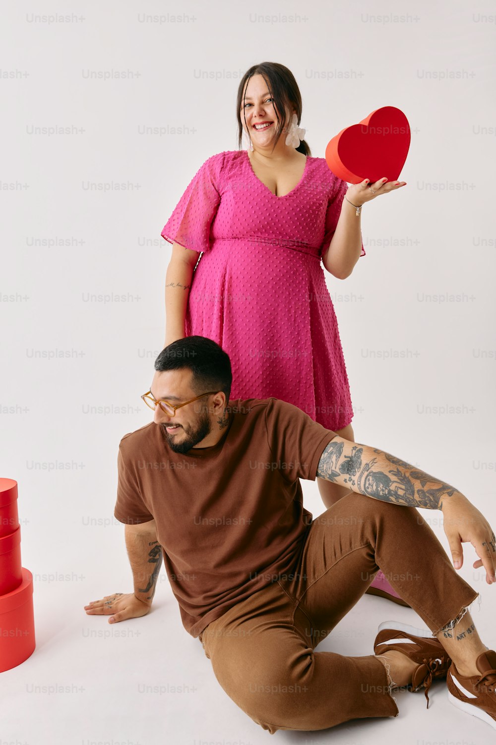 a man holding a red frisbee next to a woman