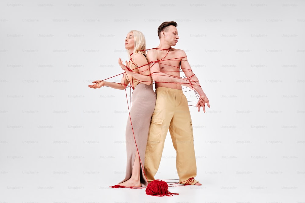a man and a woman tied up to strings