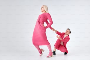 a woman in a pink dress and a man in a pink suit