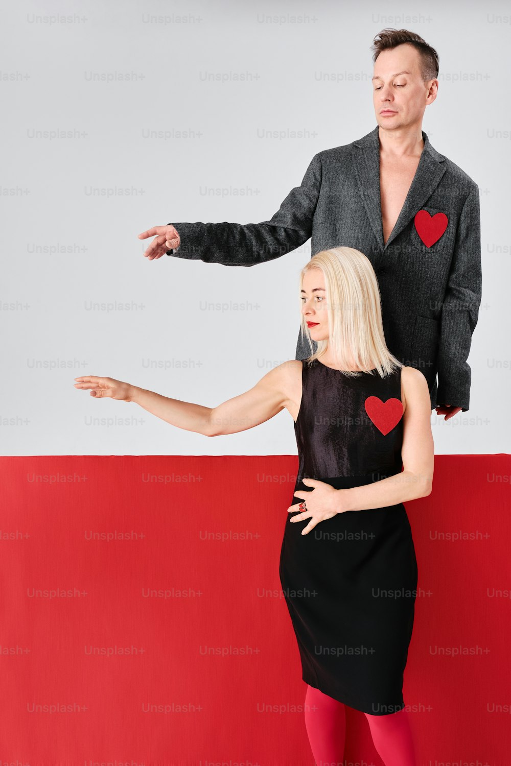 a man standing next to a woman in a black dress