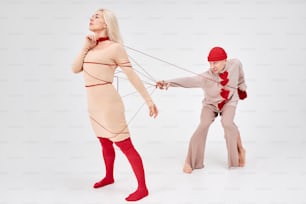 a woman pulling a man on a string