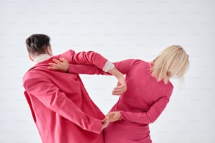a man and a woman in pink clothes are facing each other
