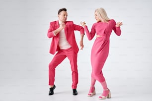 a man and woman dressed in pink dancing