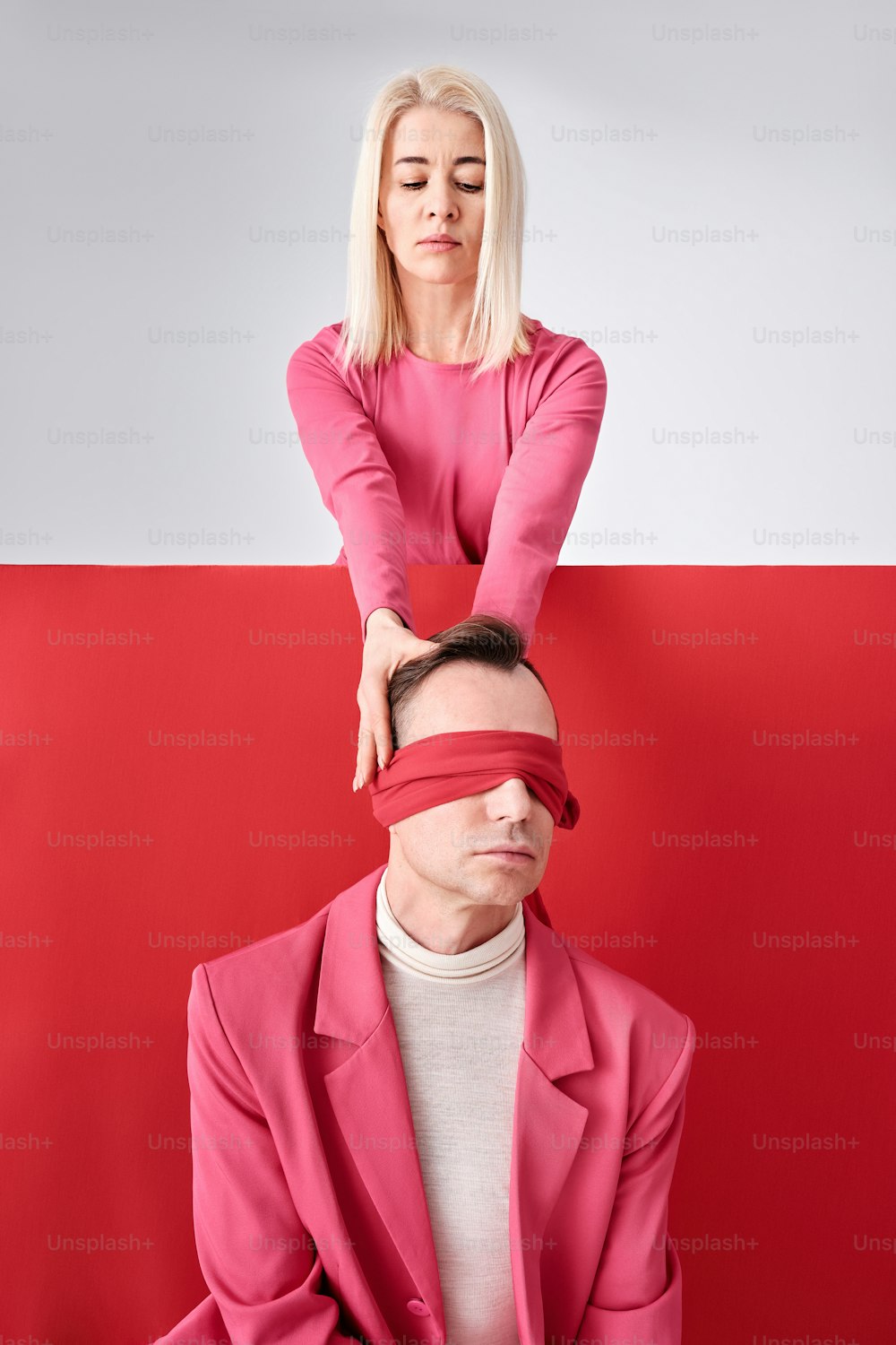 a woman covering her eyes behind a man's head