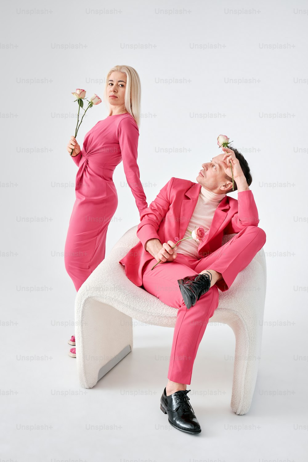 un homme en costume rose et une femme en robe rose