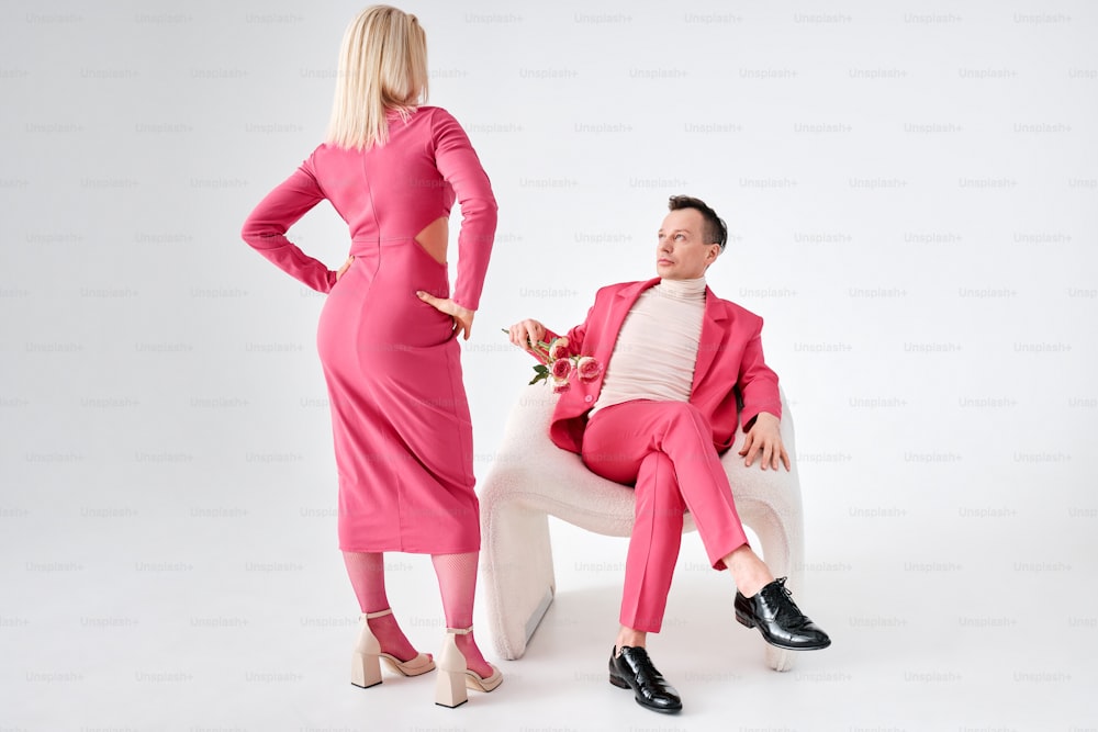 um homem de terno rosa e uma mulher de vestido branco