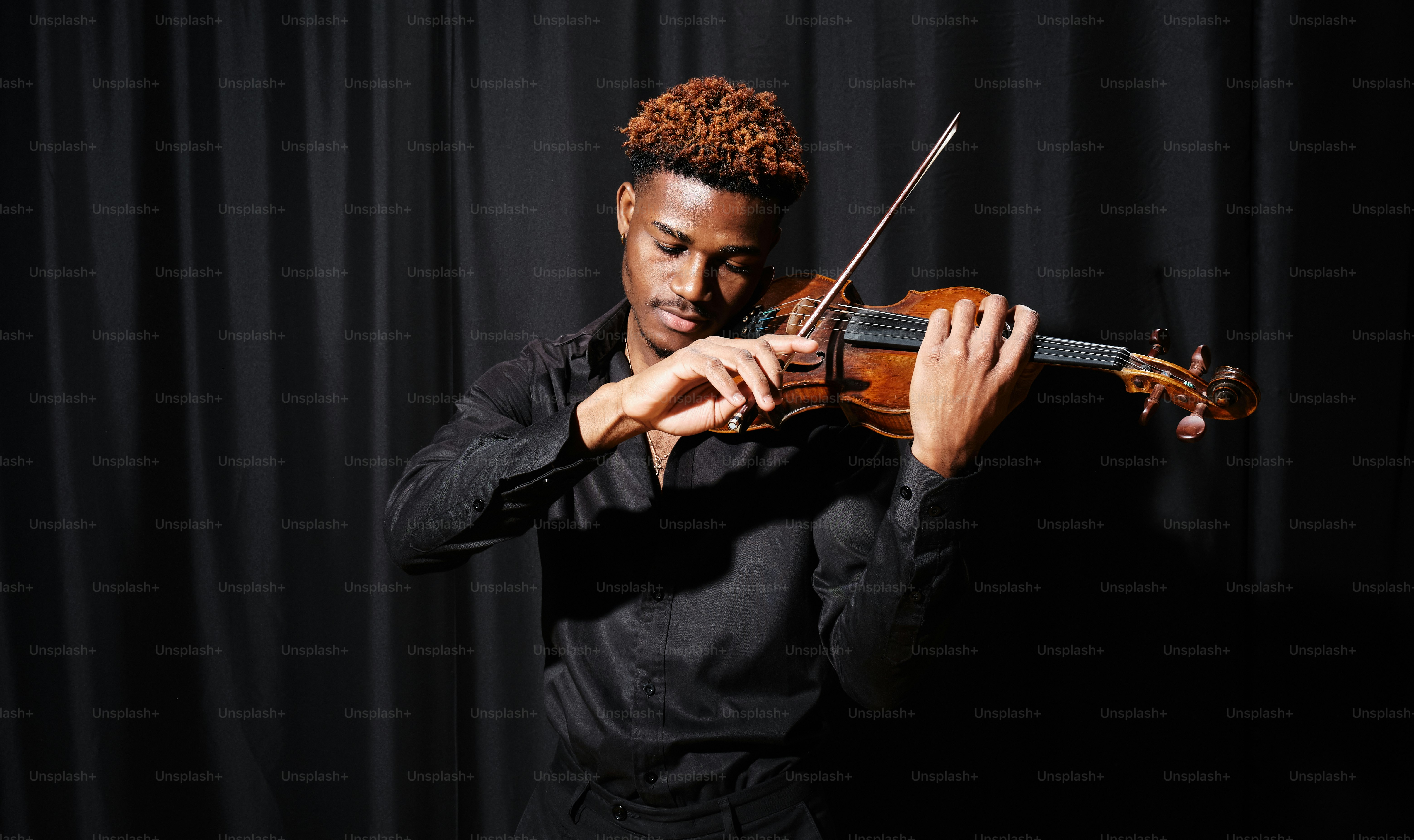 a man in a black shirt playing a violin