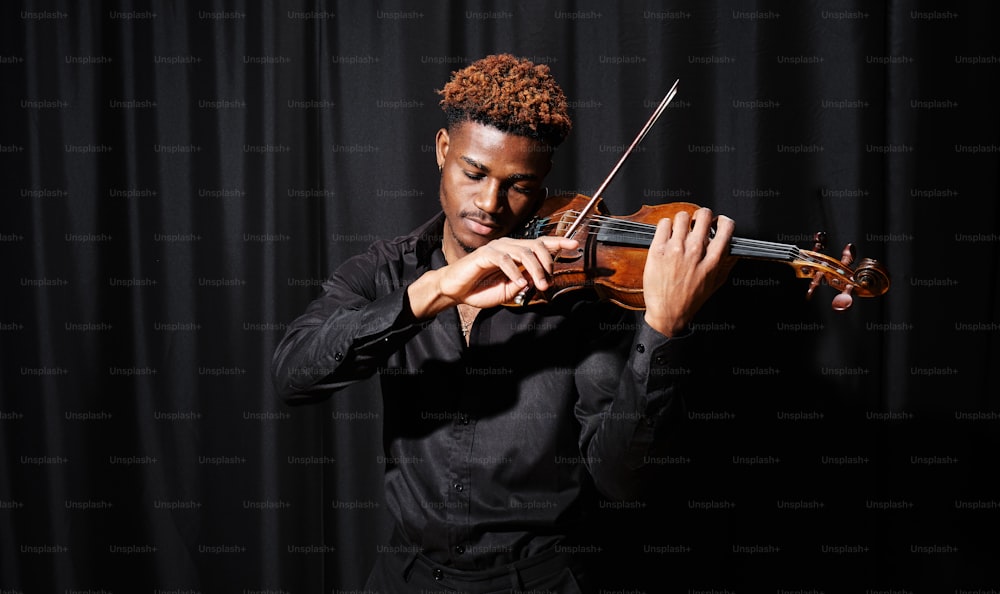a man in a black shirt playing a violin