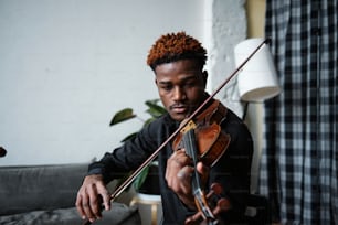a man playing a violin in a living room