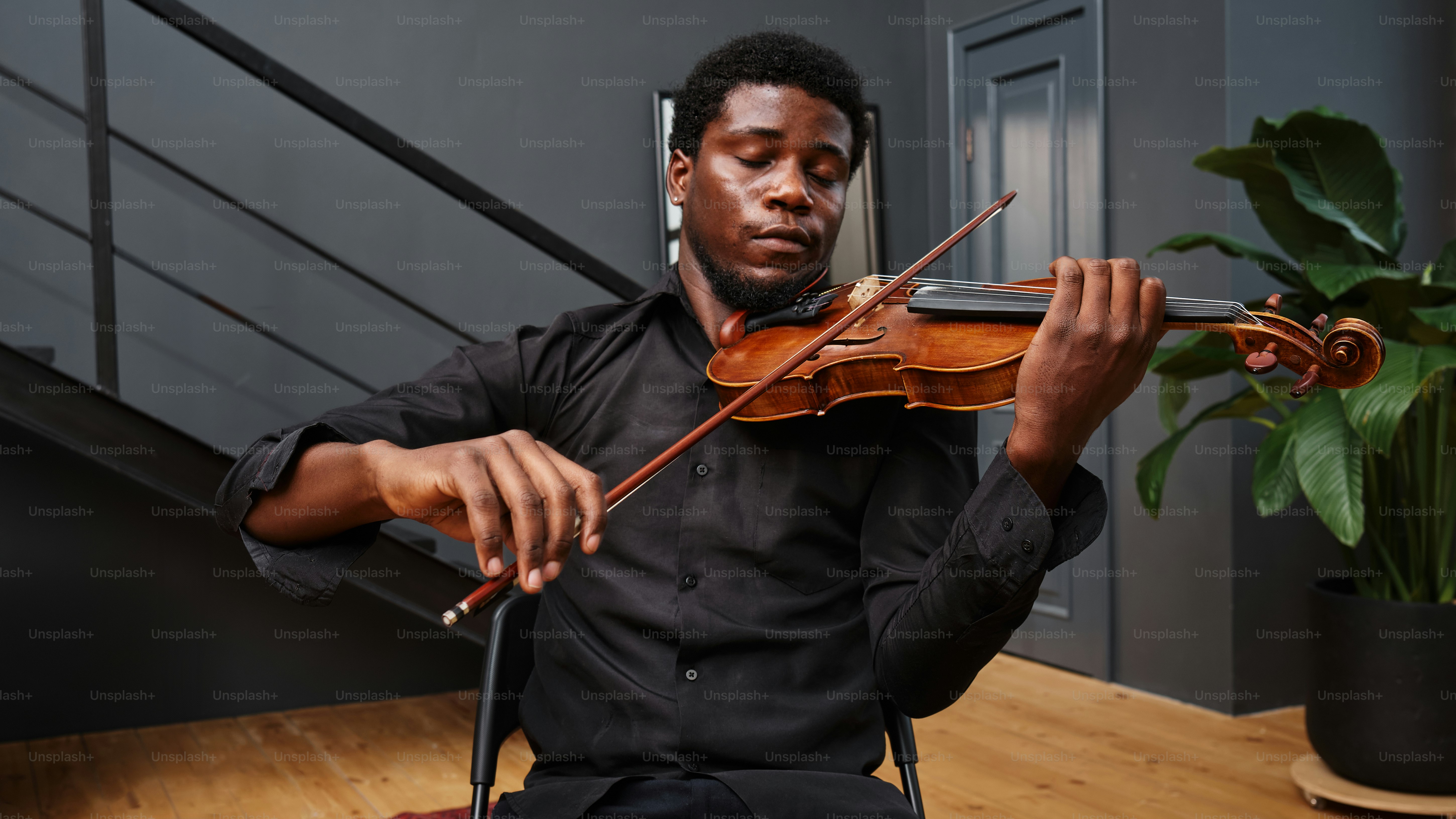 a man playing a violin on a wooden floor