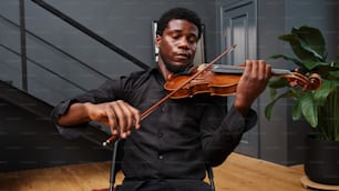 Un hombre tocando un violín en un suelo de madera