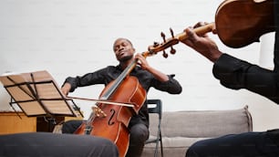 um homem tocando violino e outro homem sentado em um sofá