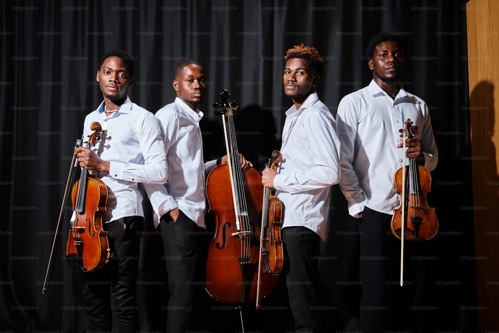 a group of men standing next to each other holding musical instruments