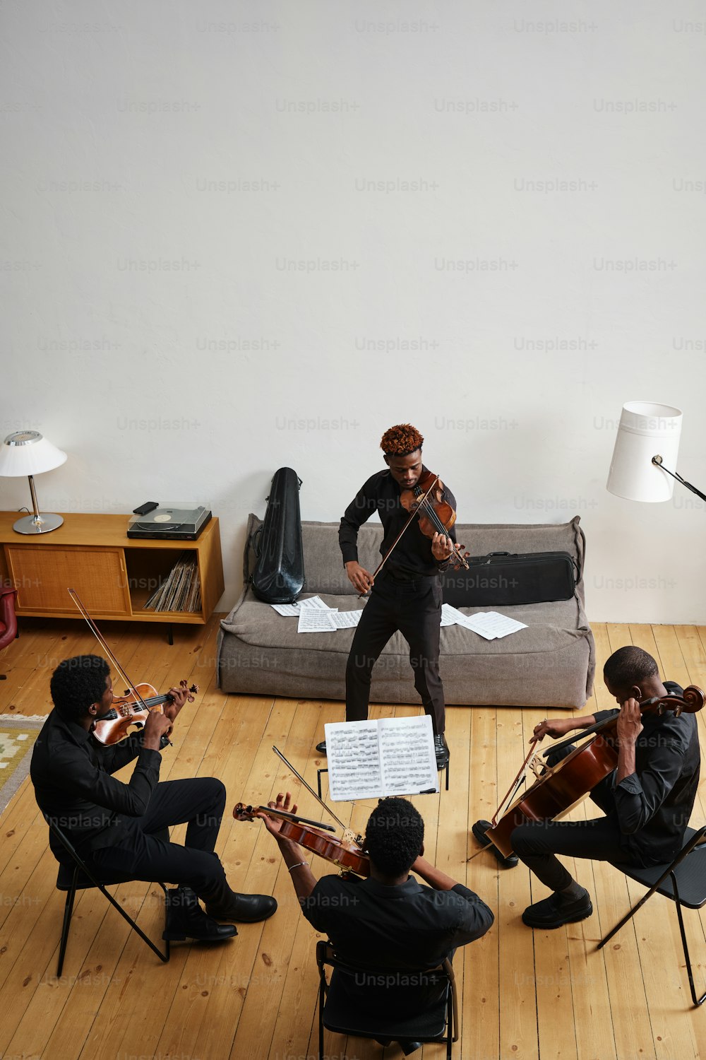 eine Gruppe von Menschen, die in einem Raum Instrumente spielen