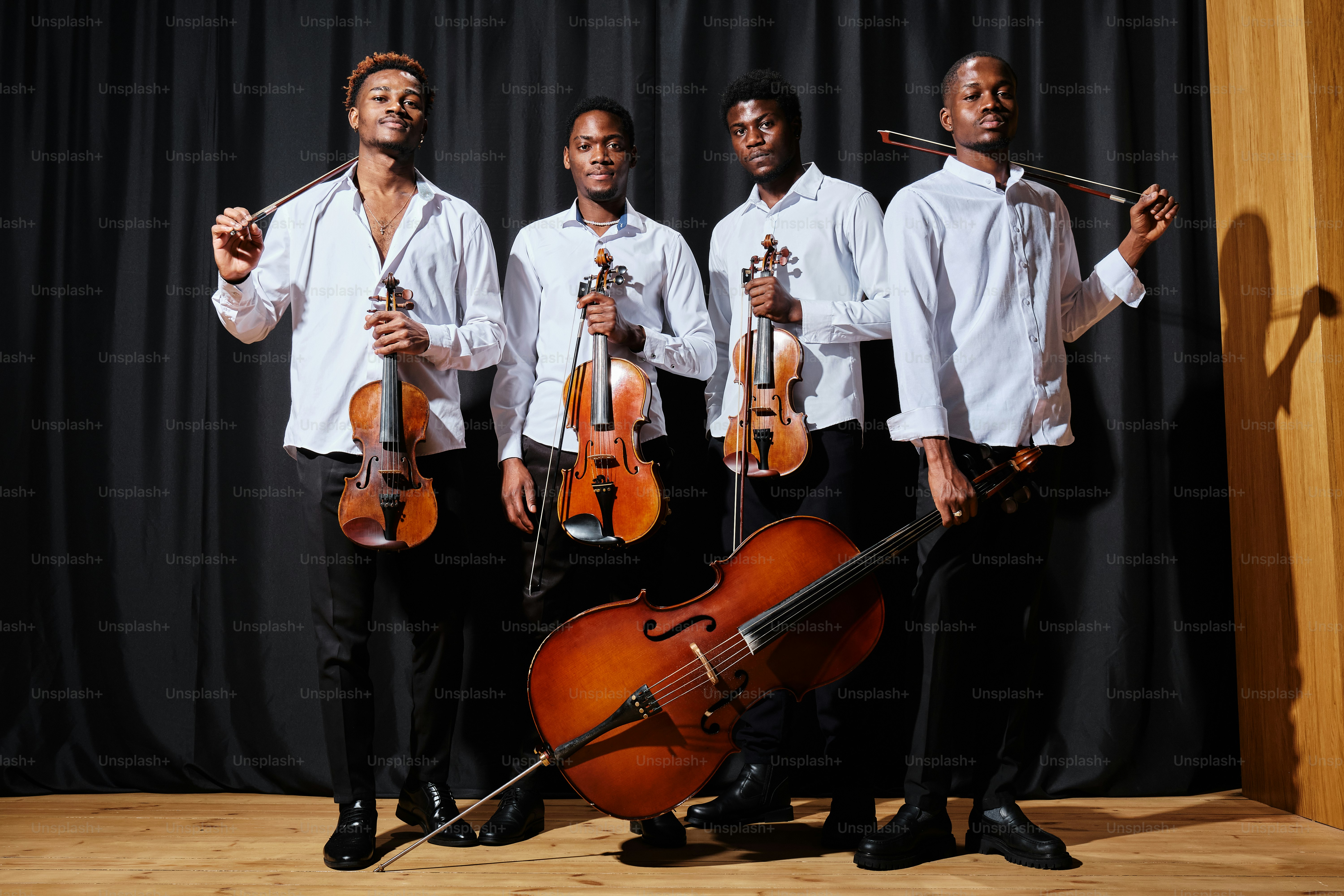 un groupe d’hommes debout les uns à côté des autres tenant des instruments de musique