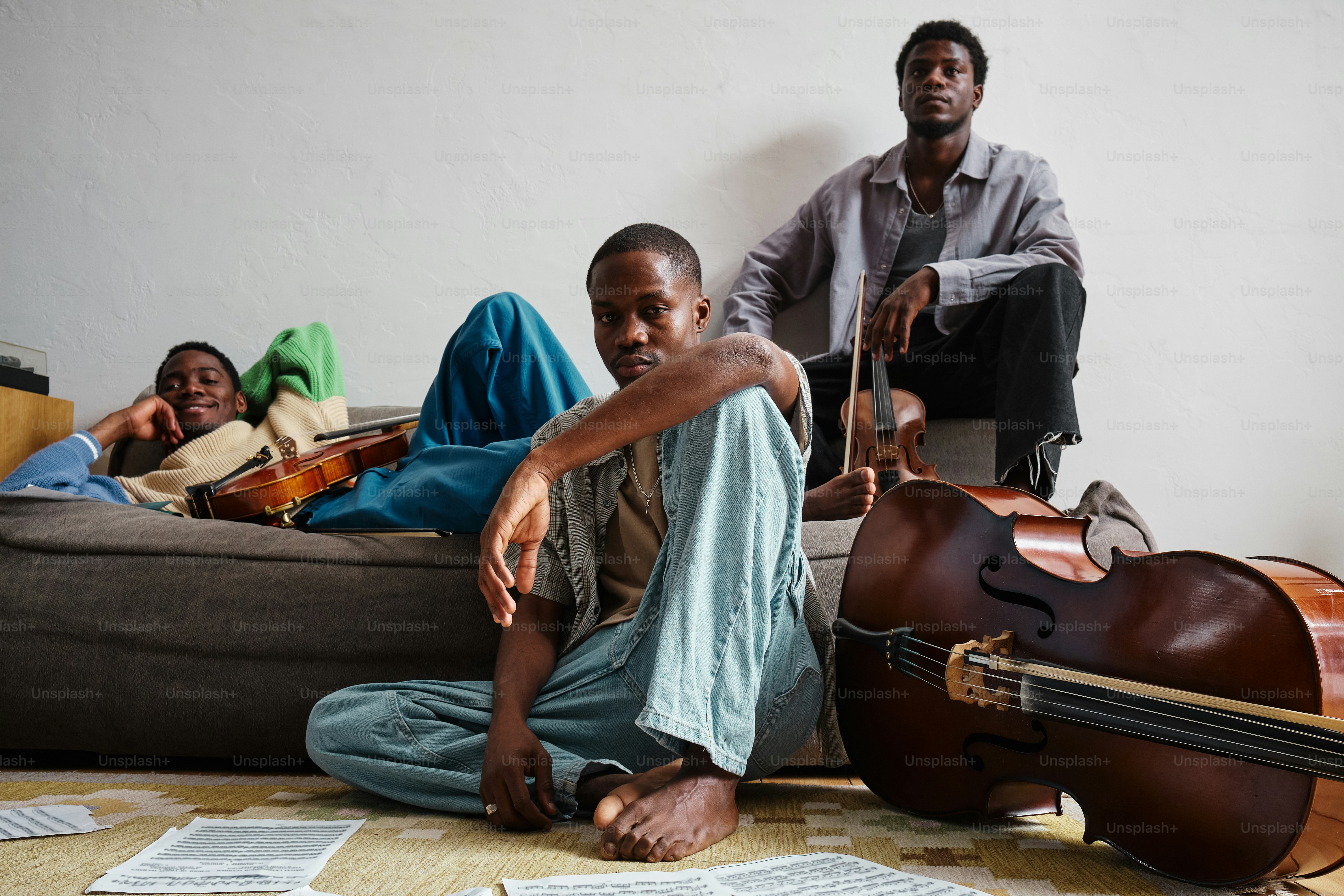 a man sitting on the floor next to a guitar
