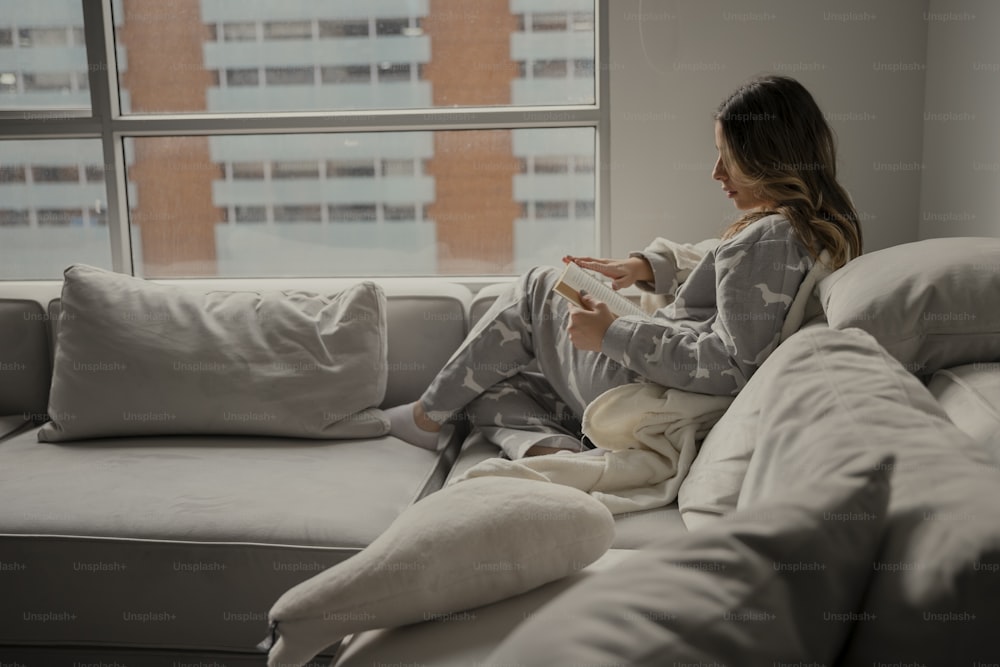 a woman sitting on a couch holding a remote