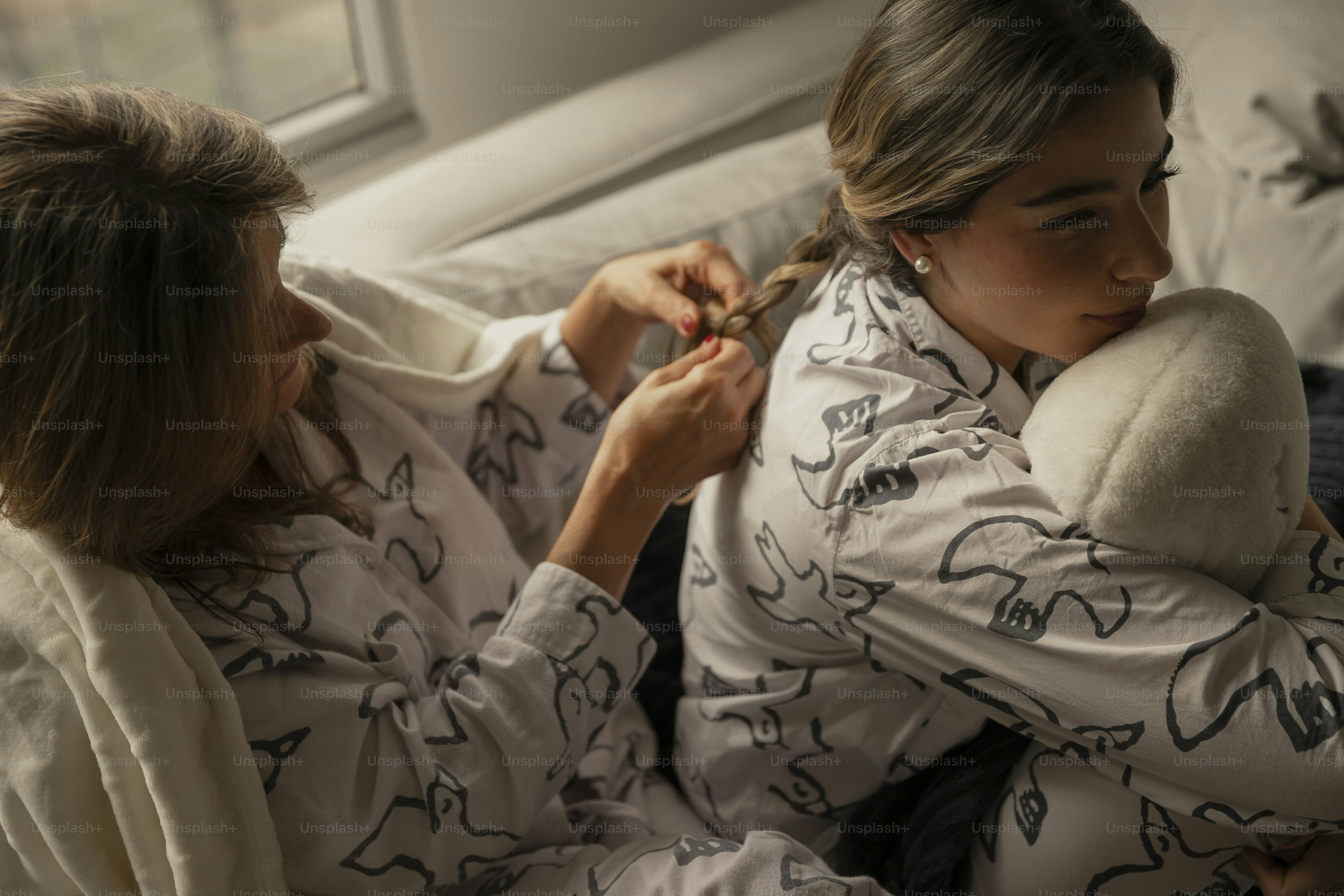 a woman sitting on a couch holding a teddy bear