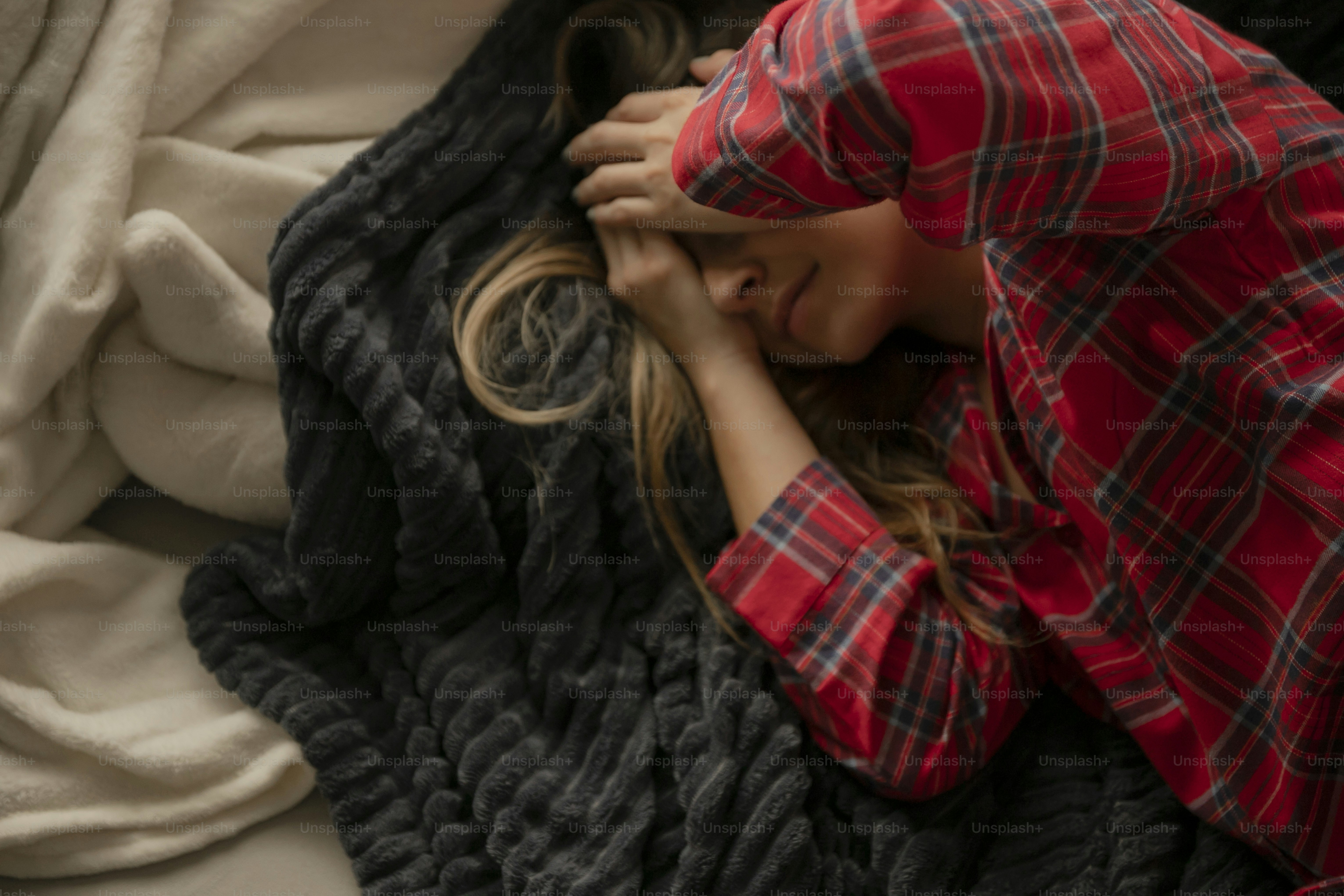 una mujer acostada encima de una manta encima de una cama