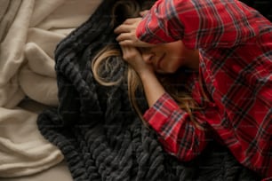 a woman laying on top of a blanket on top of a bed