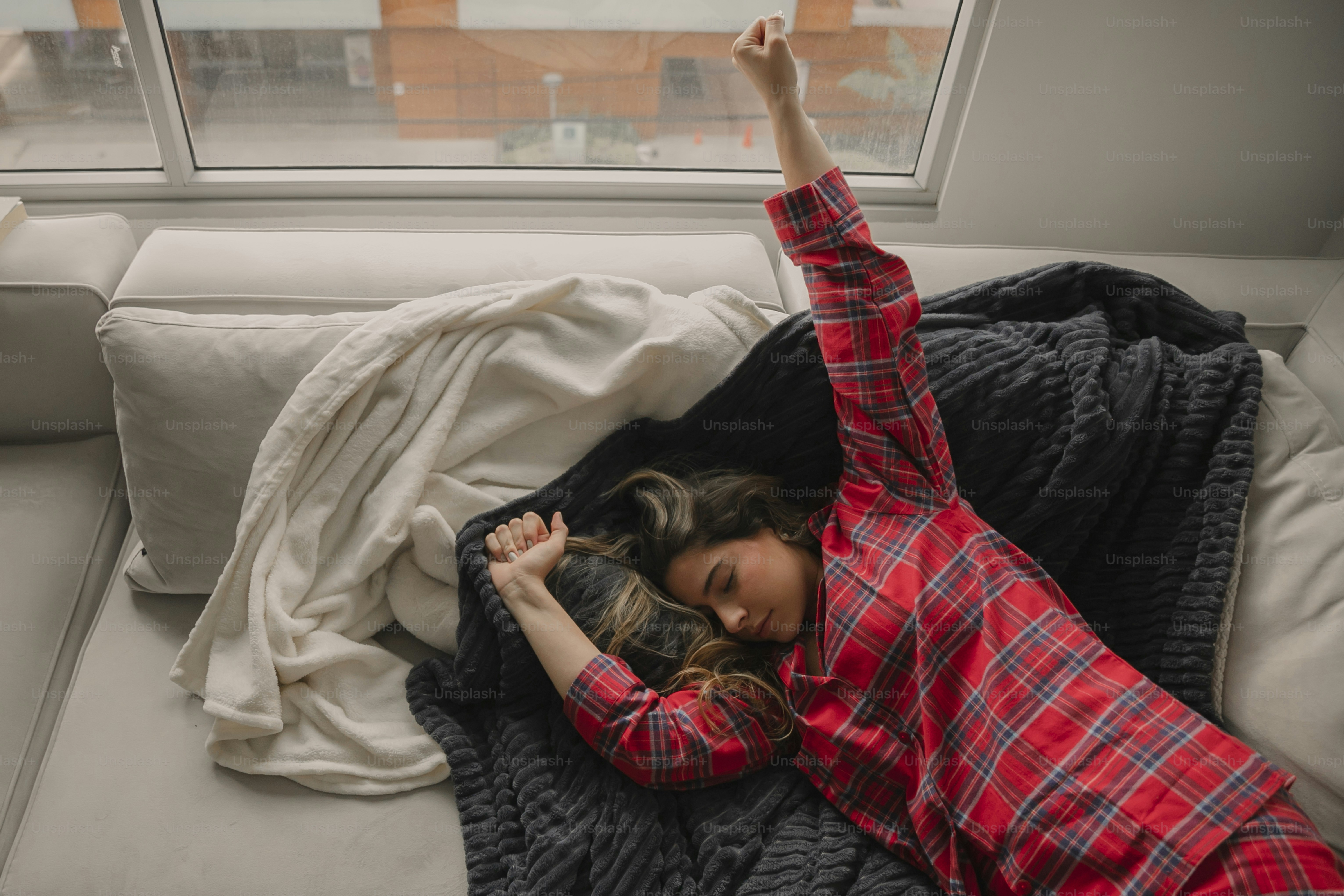 una mujer acostada en una cama con una manta