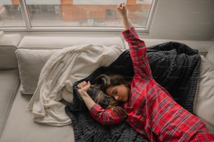 una mujer acostada en una cama con una manta