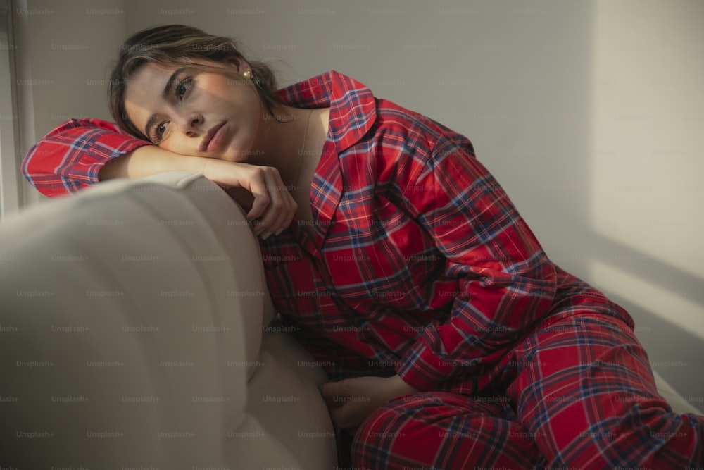 eine Frau in einem rot-blau karierten Pyjama