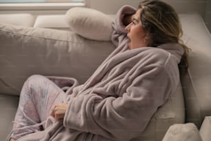 a woman laying on a couch in a robe