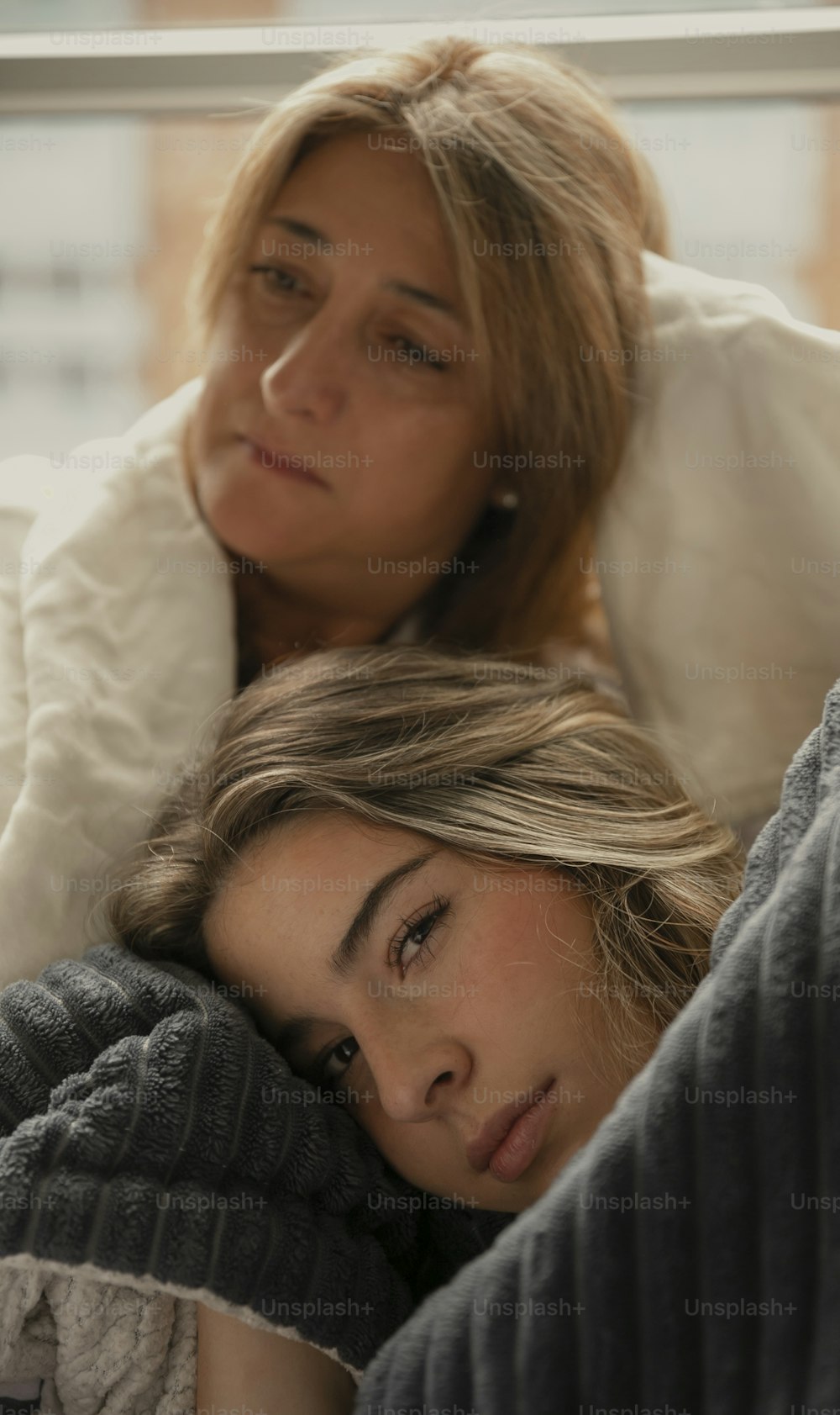 a couple of women laying on top of a bed